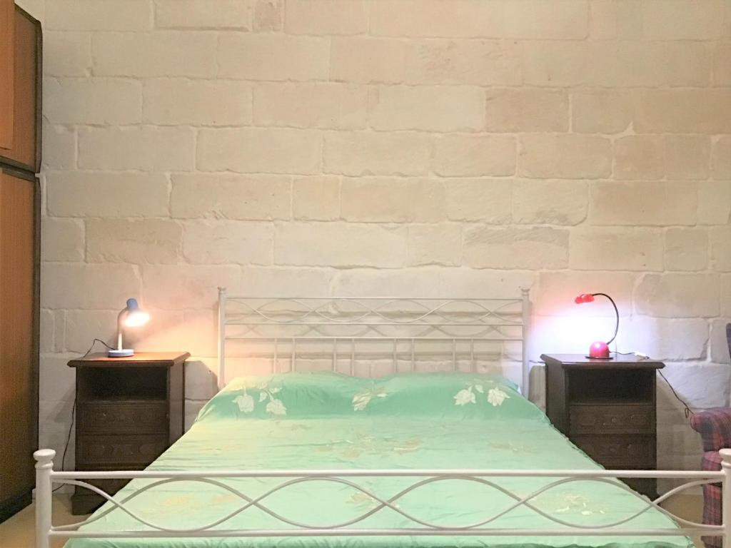um quarto com uma cama e duas mesas de cabeceira em GoodStay Dimora San Lazzaro em Lecce