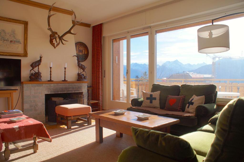 a living room with a couch and a fireplace at Central & Spacious, Richemont in Crans-Montana