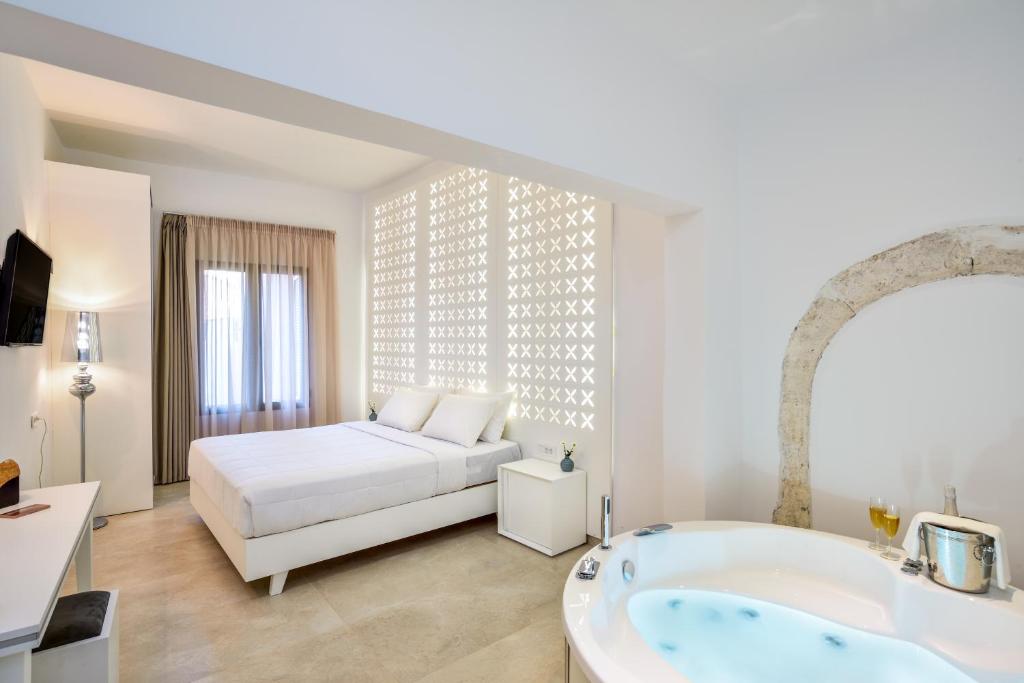 a bedroom with a bed and a tub in a room at Elia Portou Luxury Residence in Chania Town