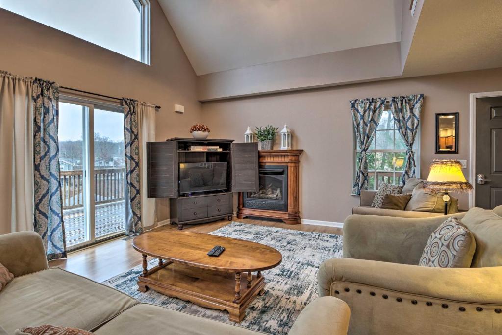 a living room with a couch and a table at Hilltop Osage Beach Home with Deck and Fire Pit! in Osage Beach