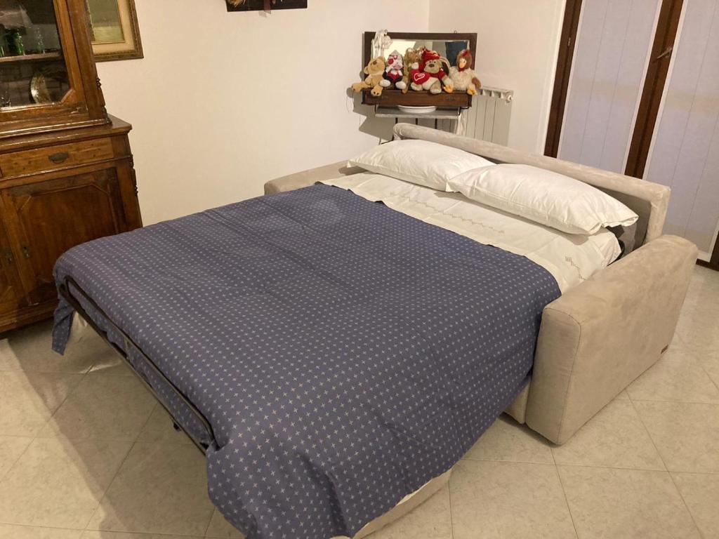1 cama con manta azul y almohadas en una habitación en la nostra casa..., en Novara