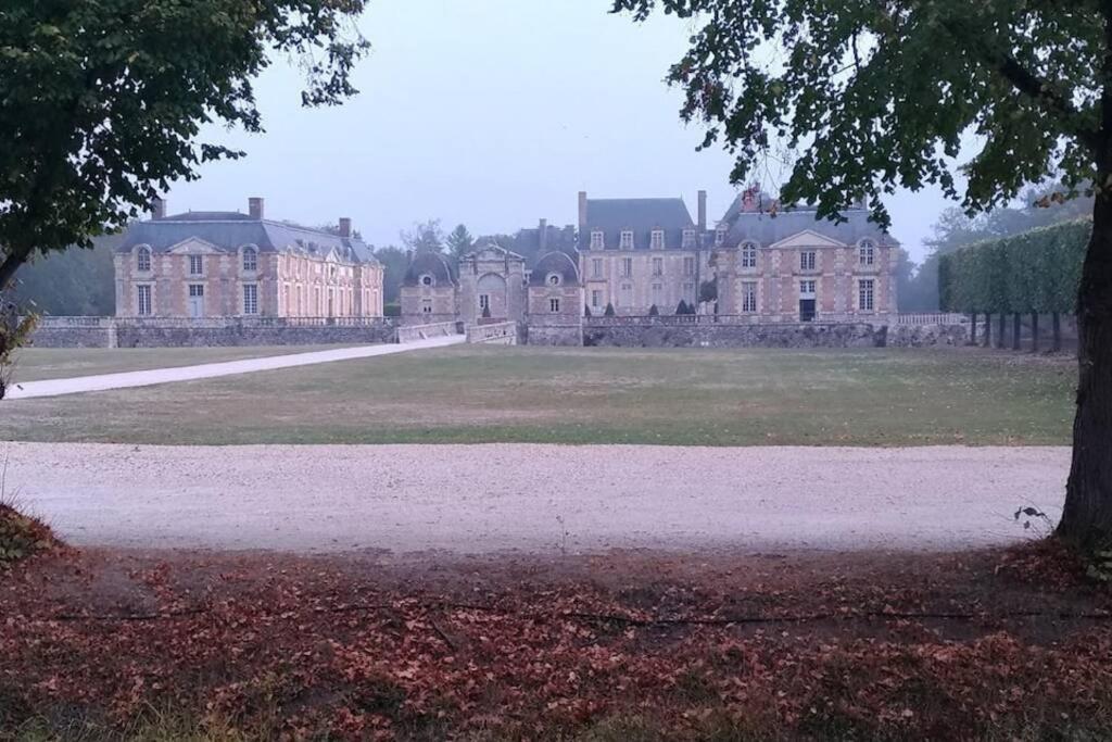 un gran edificio con un campo de césped delante de él en F2 au pied du château et à 15min de Center Parc en La Ferté-Saint-Aubin