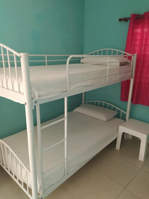 two bunk beds in a room with a chair at Hotel Tipico Maura in Bayahibe