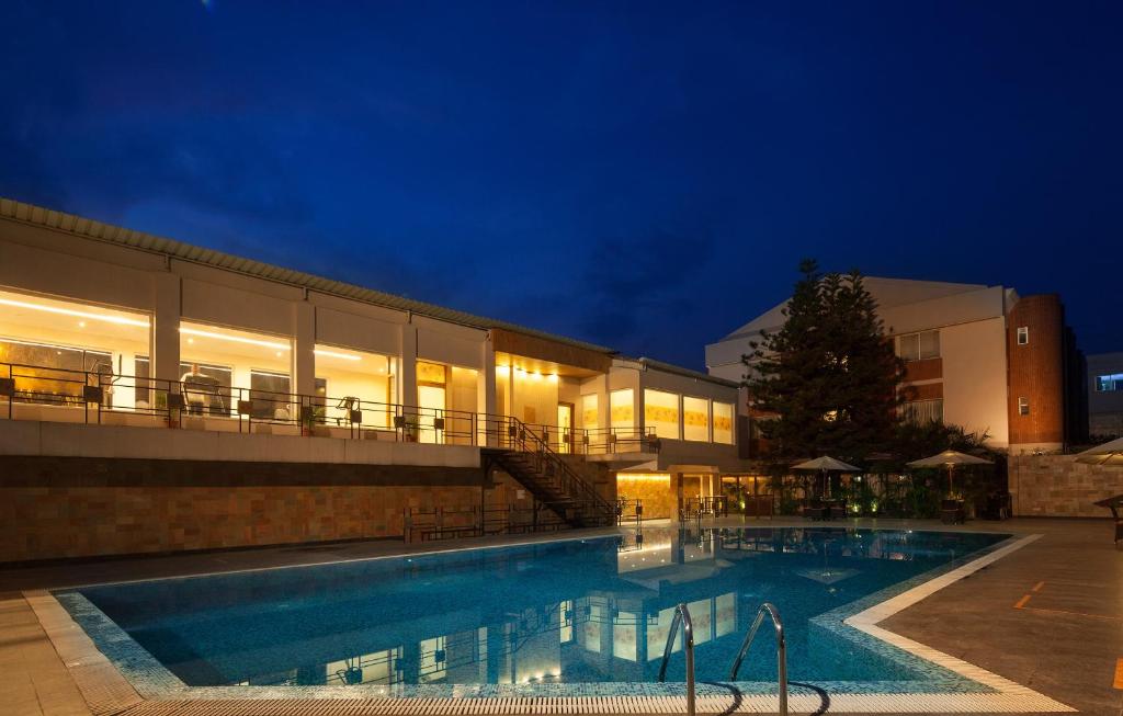 una piscina di fronte a un edificio di notte di Sinclairs Siliguri a Siliguri