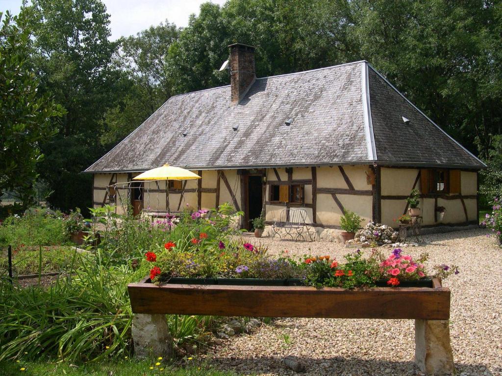 una pequeña casa con un jardín de flores delante de ella en STUARTLODGE s, en Oizon