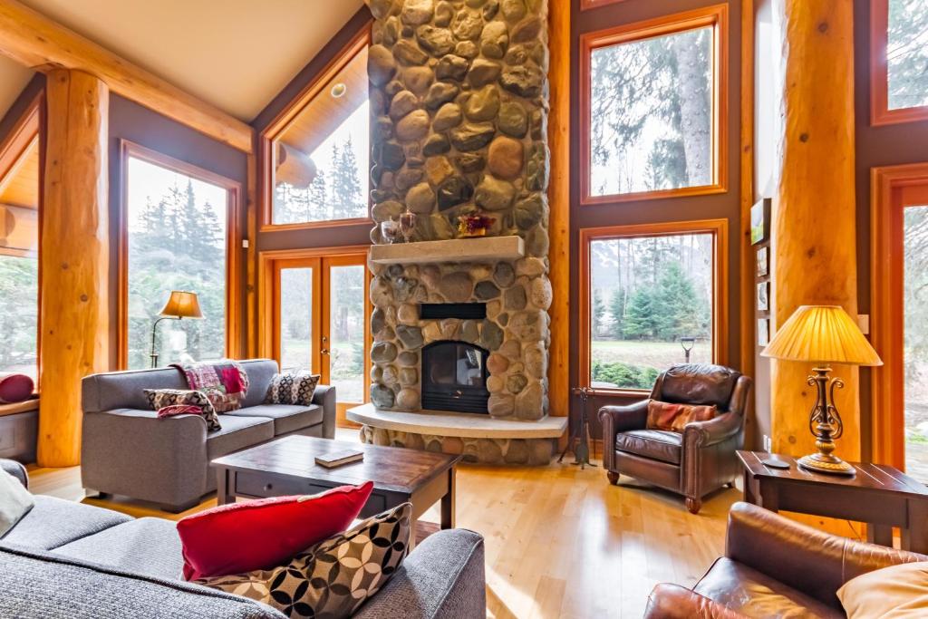 a living room with a stone fireplace in a cabin at 8140 Nicklaus North in Whistler