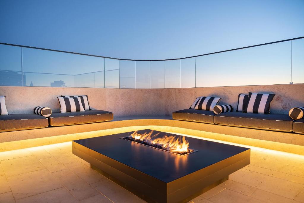 a living room with a fire pit in the middle at 3HB Faro in Faro