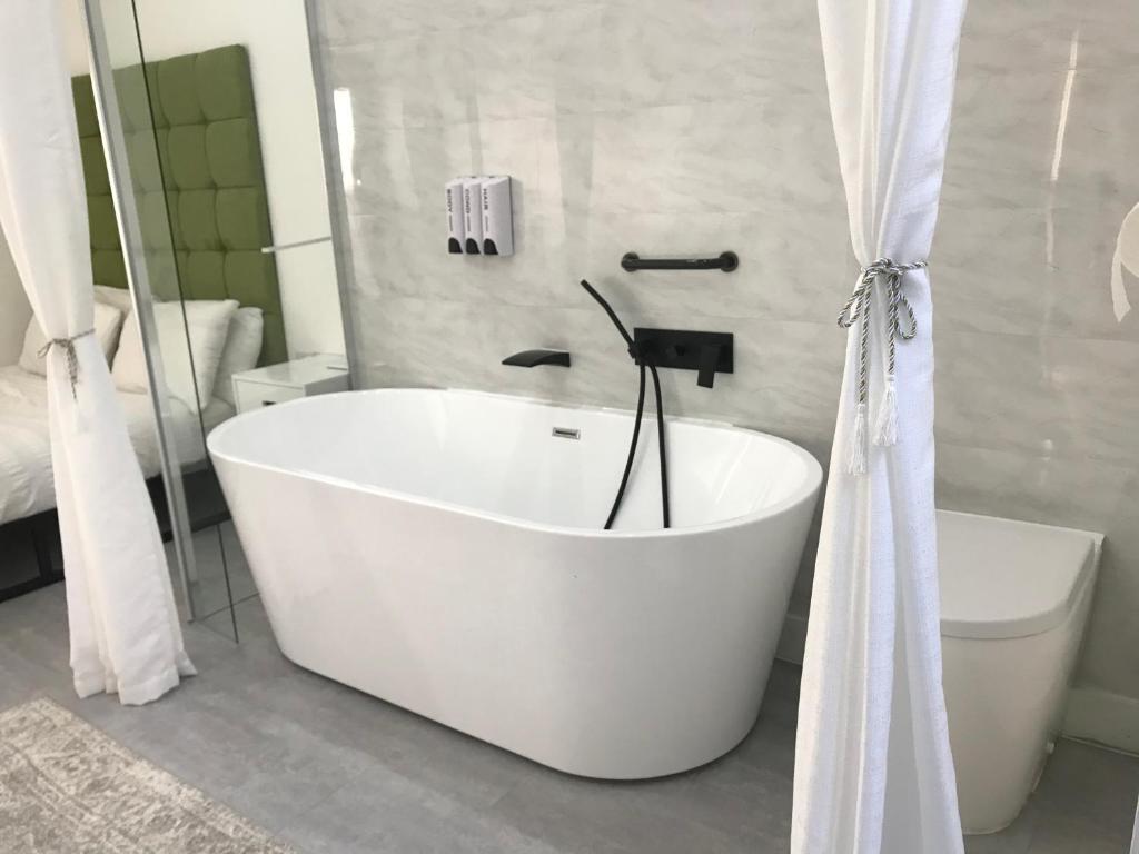 La salle de bains est pourvue d'une baignoire blanche et de toilettes. dans l'établissement Apartment style Space, à Minworth