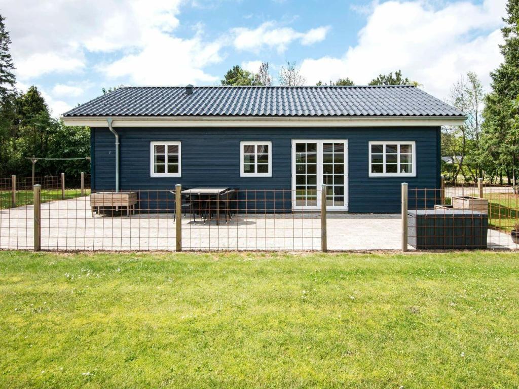 a blue house with a fence in front of it at 4 person holiday home in Ansager in Ansager