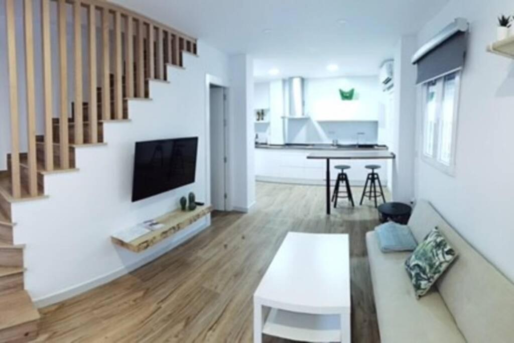 a living room with a staircase and a couch and a table at Preciosa Casita Armilla in Armilla