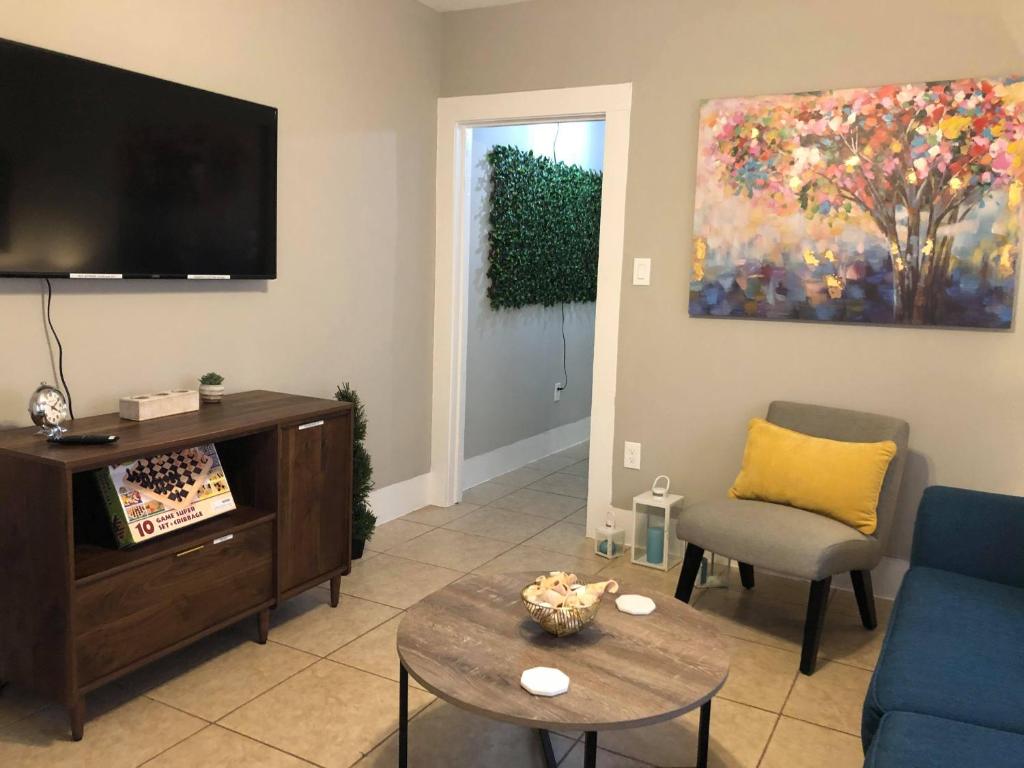 a living room with a tv and a couch and a table at The Comfi Coral - Large 1 Bedroom Studio A in Baytown