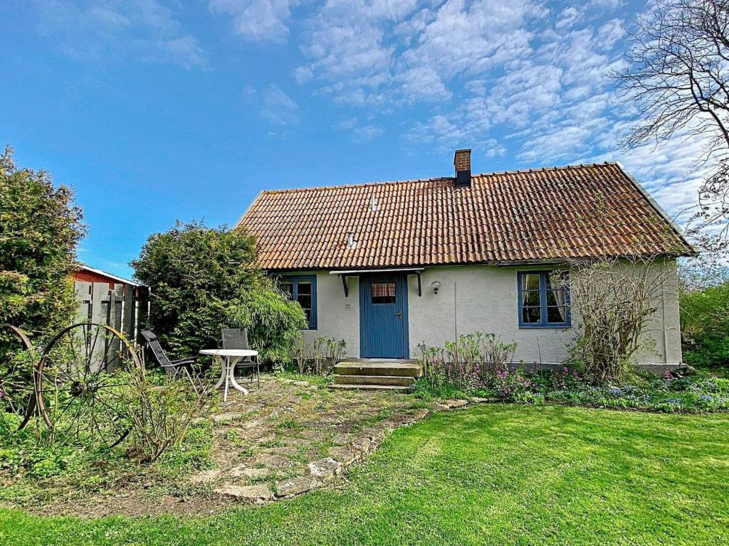 une petite maison blanche avec une porte bleue dans l'établissement Holiday home LÖTTORP VII, à Löttorp