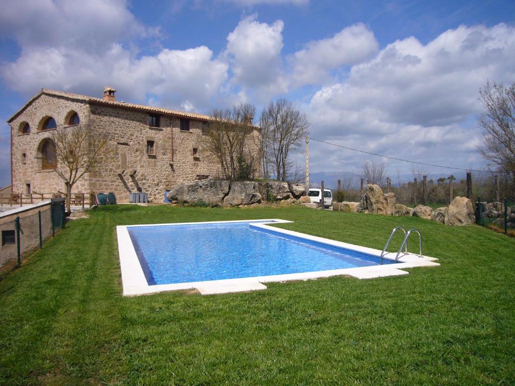 una casa con piscina frente a un edificio en Masia Rovira, en Pinell de Solsonès