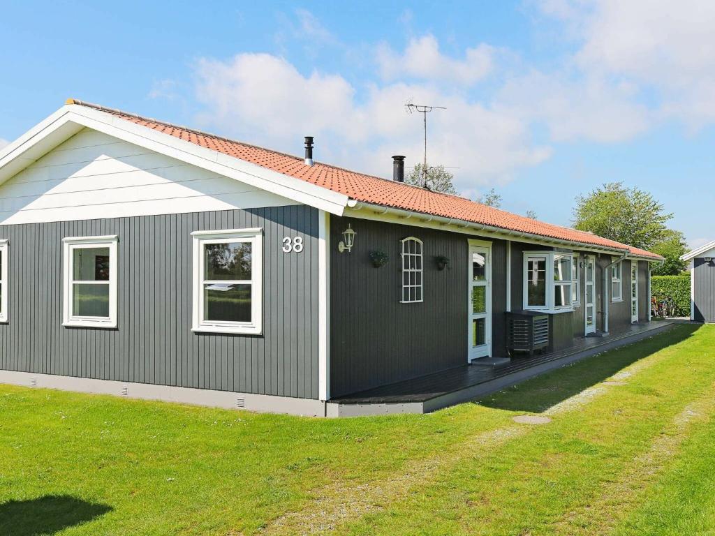 una casa gris y blanca con un patio en 12 person holiday home in Hadsund, en Nørre Hurup