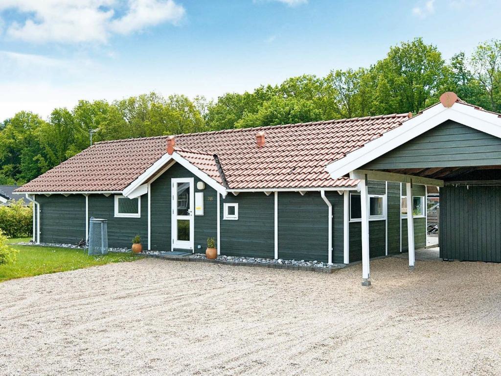 a green house with a brown roof at 8 person holiday home in Juelsminde in Sønderby
