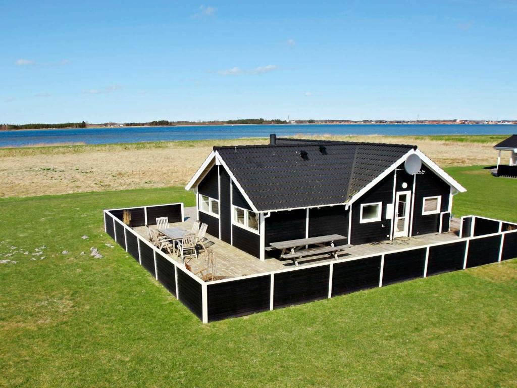 a house on a dock in a field of grass at 6 person holiday home in Storvorde-By Traum in Egense