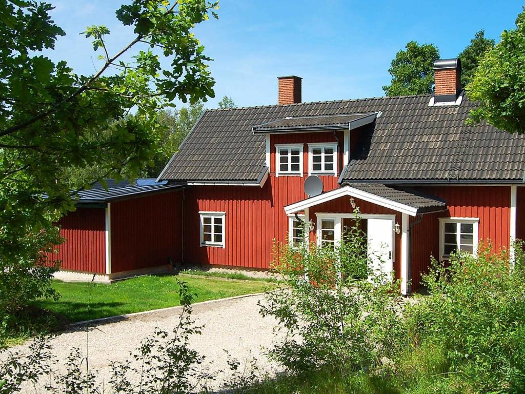 una casa roja con techo rojo en Four-Bedroom Holiday home in Mellerud, en Dals Rostock