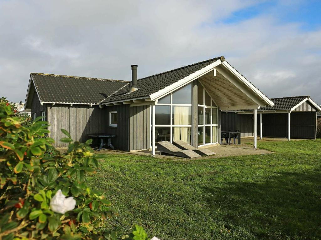 a house with a large window on a yard at 6 person holiday home in Harbo re in Harboør