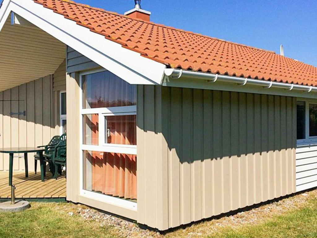 ein kleiner Schuppen mit einem Tisch auf dem Deck in der Unterkunft 6 person holiday home in Gelting in Gelting