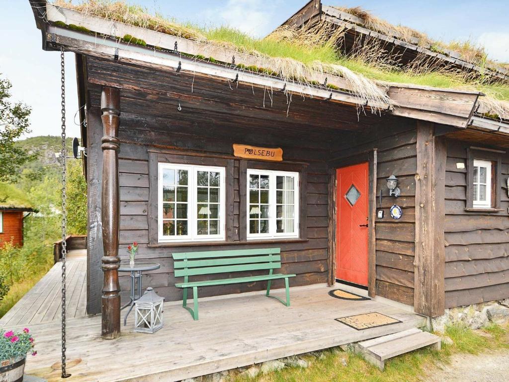 uma pequena cabana com um banco e um telhado de relva em 10 person holiday home in HOVDEN em Hovden