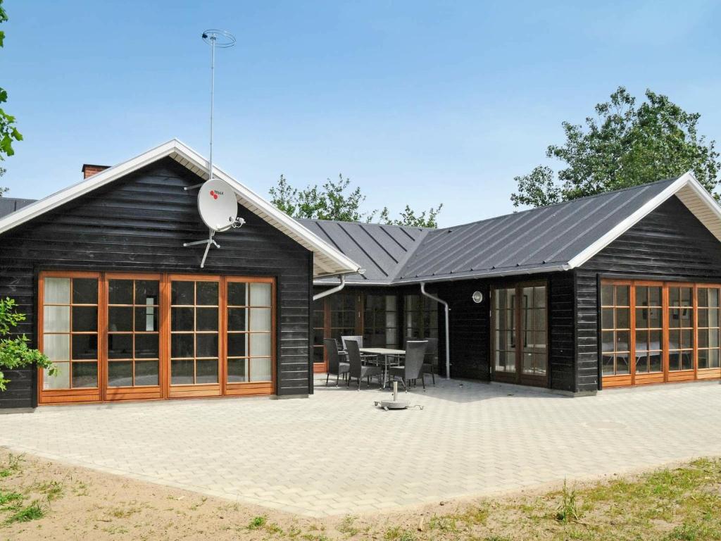 una casa negra con un patio delante en 6 person holiday home in Bl vand, en Blåvand
