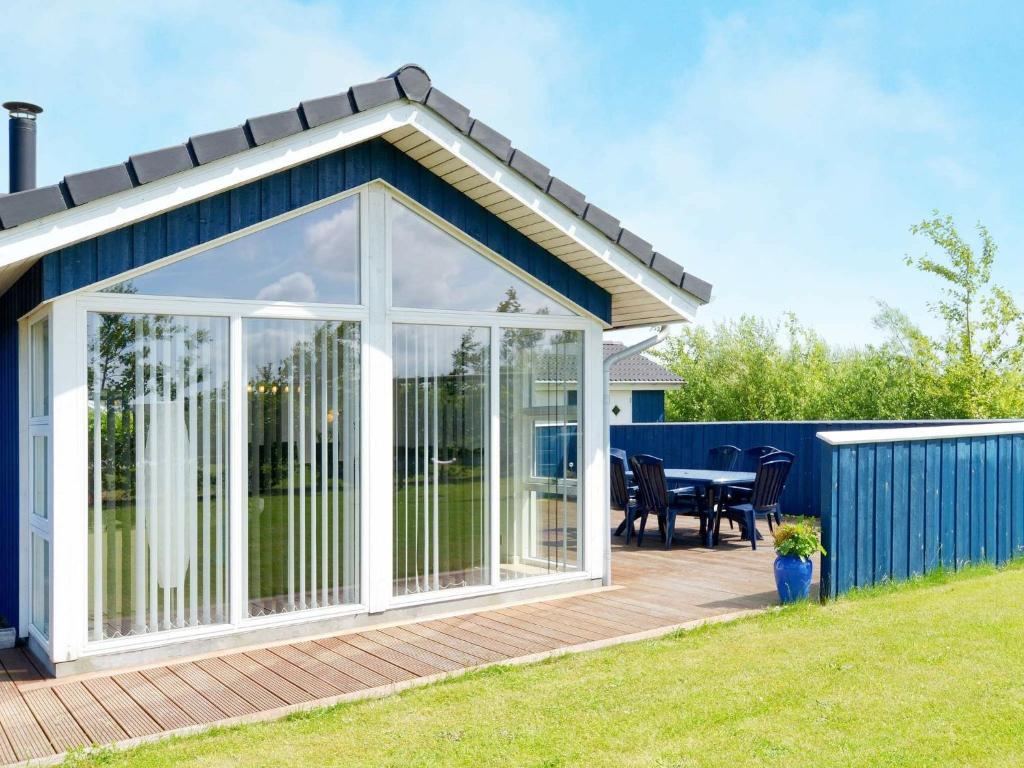 a conservatory with a table on a deck at Three-Bedroom Holiday home in Hemmet 52 in Hemmet