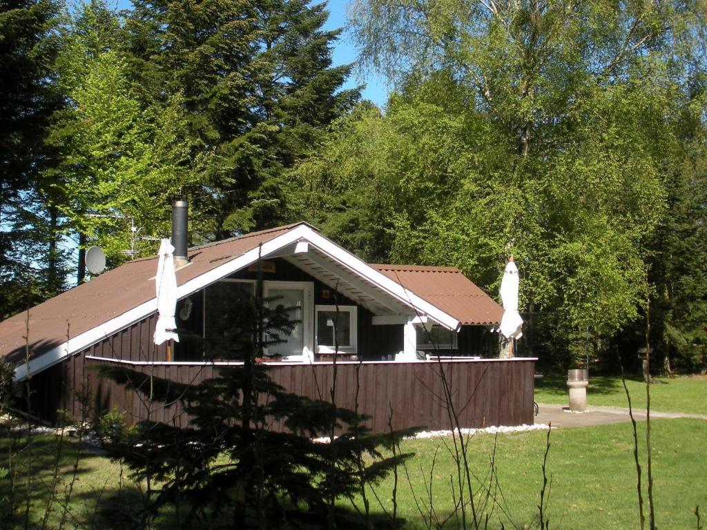 eine kleine Hütte auf einem Feld mit Bäumen in der Unterkunft 4 person holiday home in Jerup in Jerup
