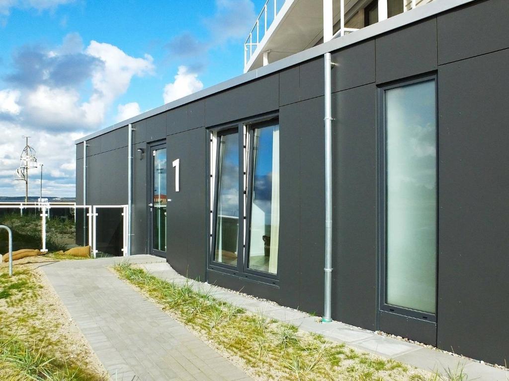 a black building with large windows on the side of it at 3 person holiday home in Wendtorf in Wendtorf