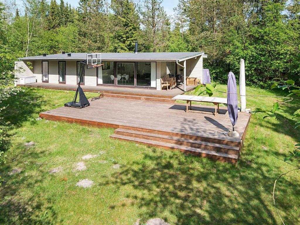 a house with a deck and a picnic table in a yard at Three-Bedroom Holiday home in Bording 3 in Bording Stationsby