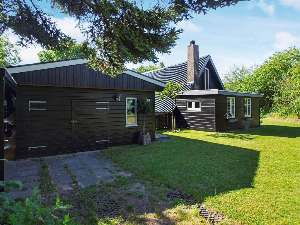 a house with a garage and a grass yard at 6 person holiday home in Hemmet in Hemmet