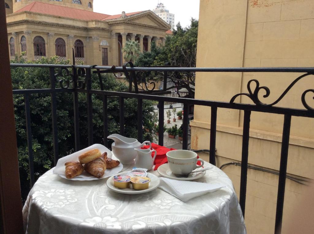 un tavolo con tè e pasticcini su un balcone di Albergo Verdi a Palermo