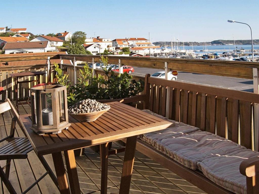 a wooden table and bench on a balcony with a harbor at 4 person holiday home in ELL S in Ellös