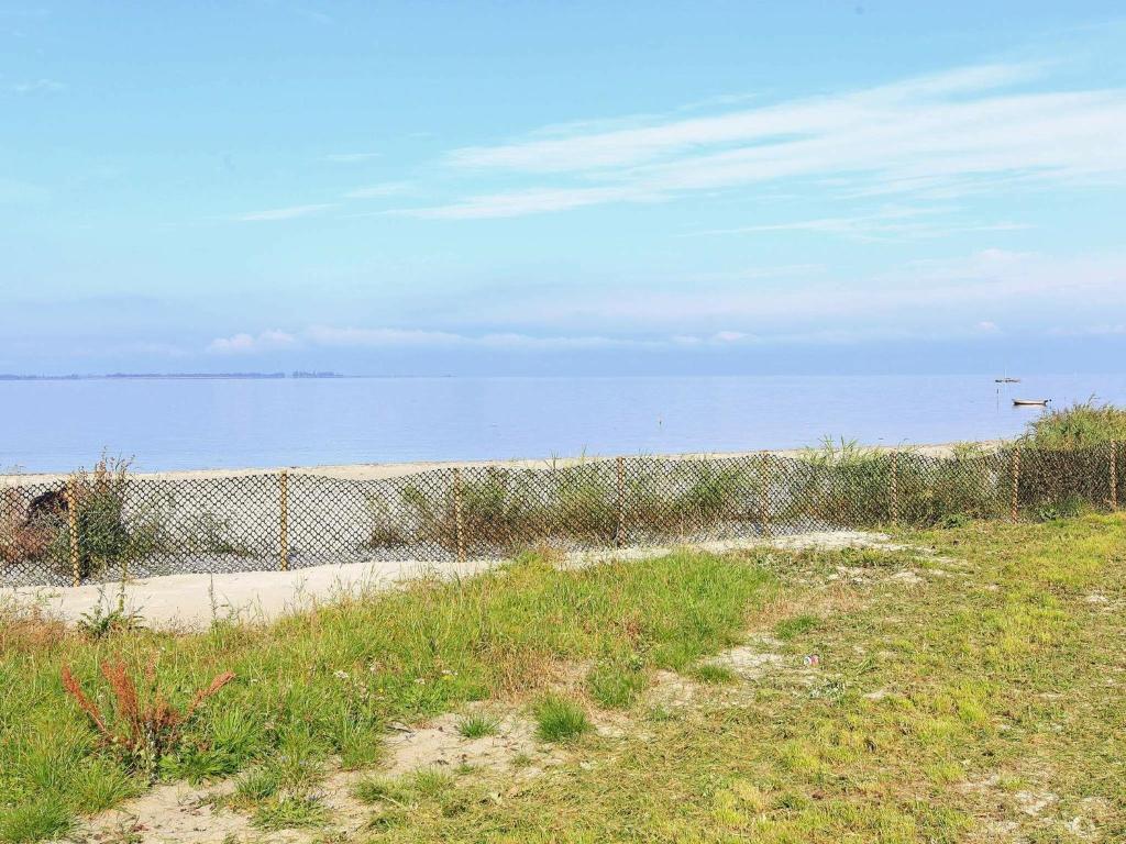 BandholmにあるHoliday Home Havnepladsenの海を背景に海岸の柵
