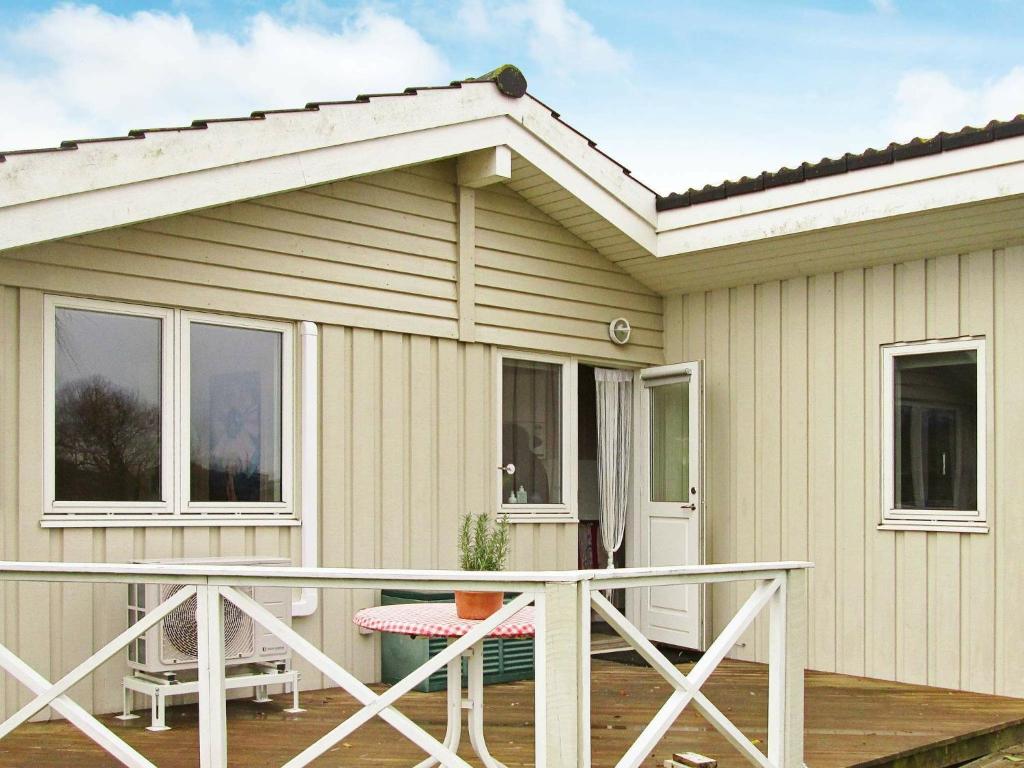 ein kleines Haus mit einer Veranda und einer Terrasse in der Unterkunft Holiday Home Skovløbervej in Rude