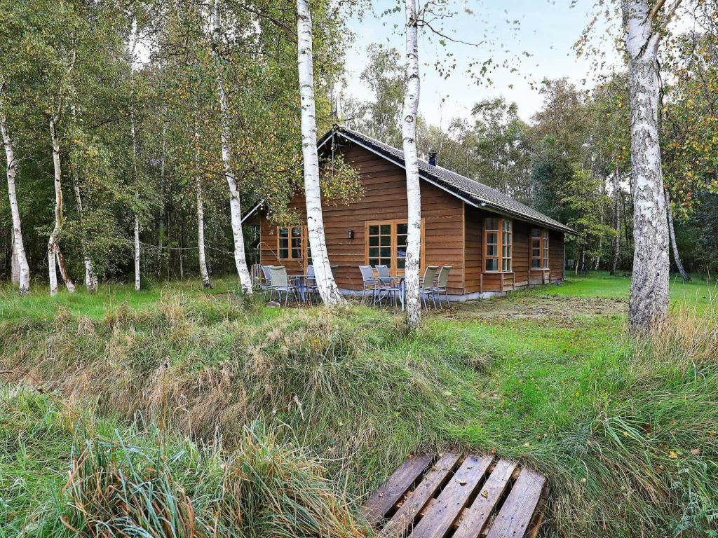 uma cabana de madeira no meio de uma floresta em 6 person holiday home in L s em Læsø