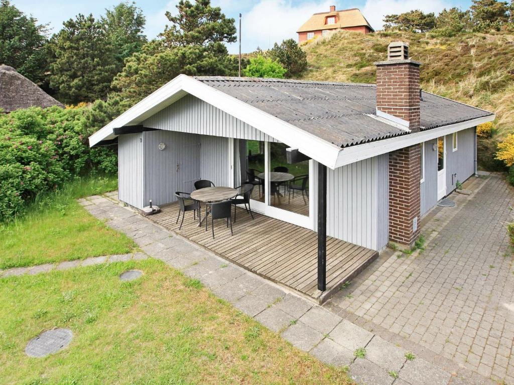 a house with a deck with a table on it at 5 person holiday home in Henne in Henne Strand