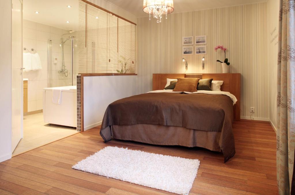 1 dormitorio con 1 cama grande y baño en Hotell Uddewalla, en Uddevalla