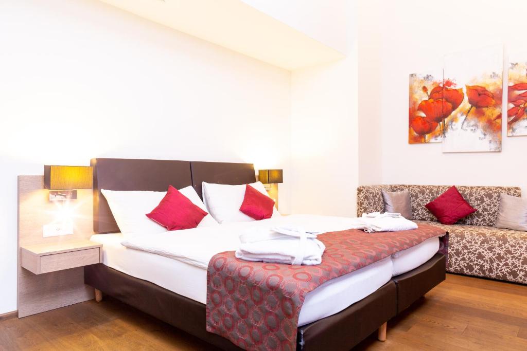 um quarto com uma cama com almofadas vermelhas em Hotel Alexander em Basileia