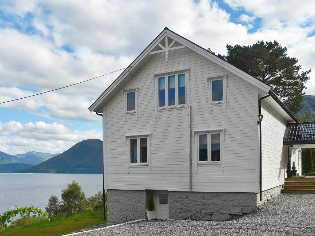 una casa bianca accanto a un corpo d'acqua di Holiday Home Eliasgården a Folkestad