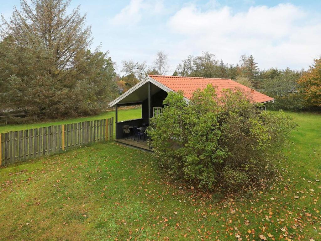 a small house in a yard with a fence at 6 person holiday home in Hals in Hals