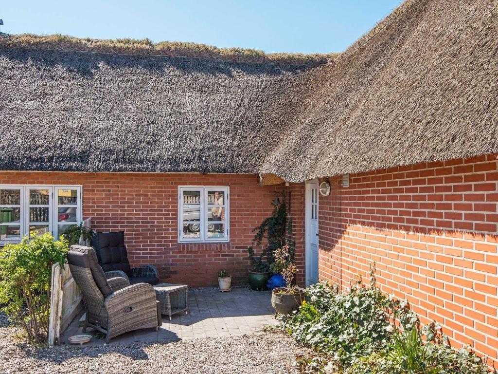 une maison en briques avec 2 chaises et une terrasse dans l'établissement Apartment Børkop, à Børkop