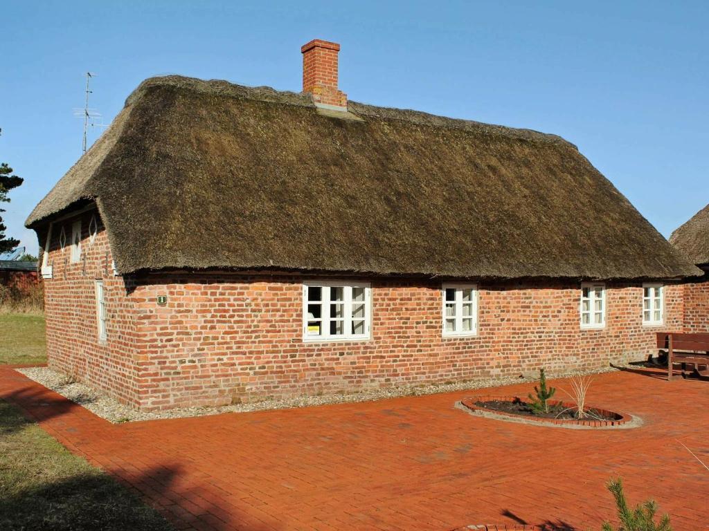 ブラーバンドにあるOne-Bedroom Holiday home in Blåvand 3の茅葺き屋根の大きなレンガ造り