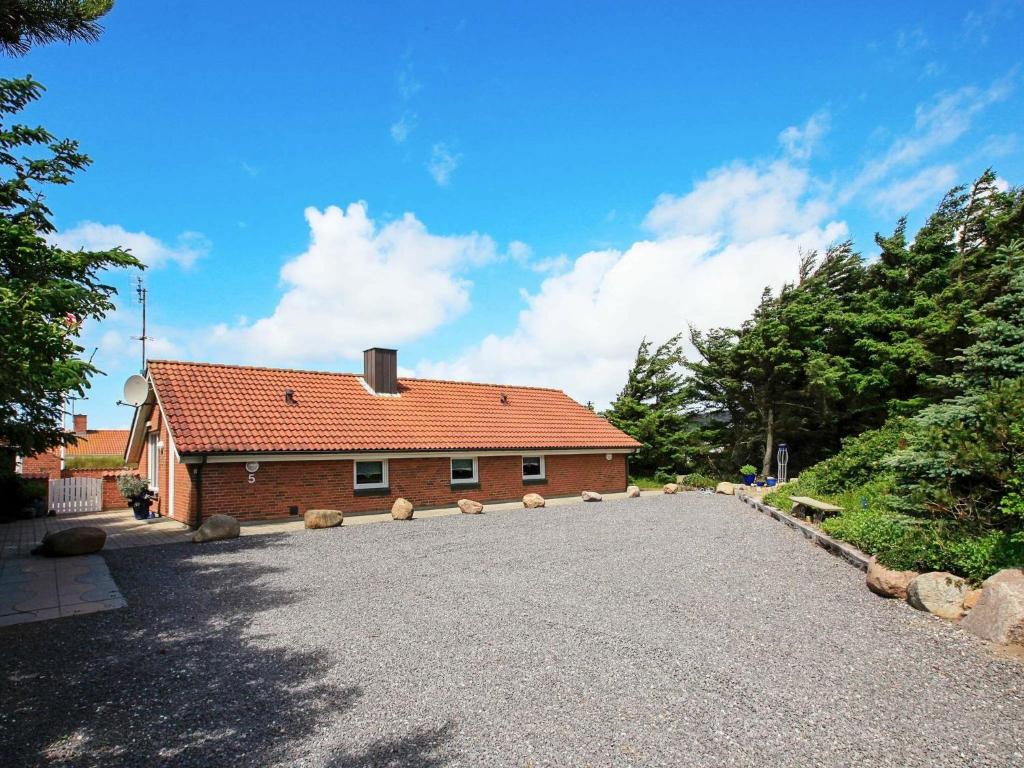 a house with a gravel driveway in front of it at 8 person holiday home in Harbo re in Harboør