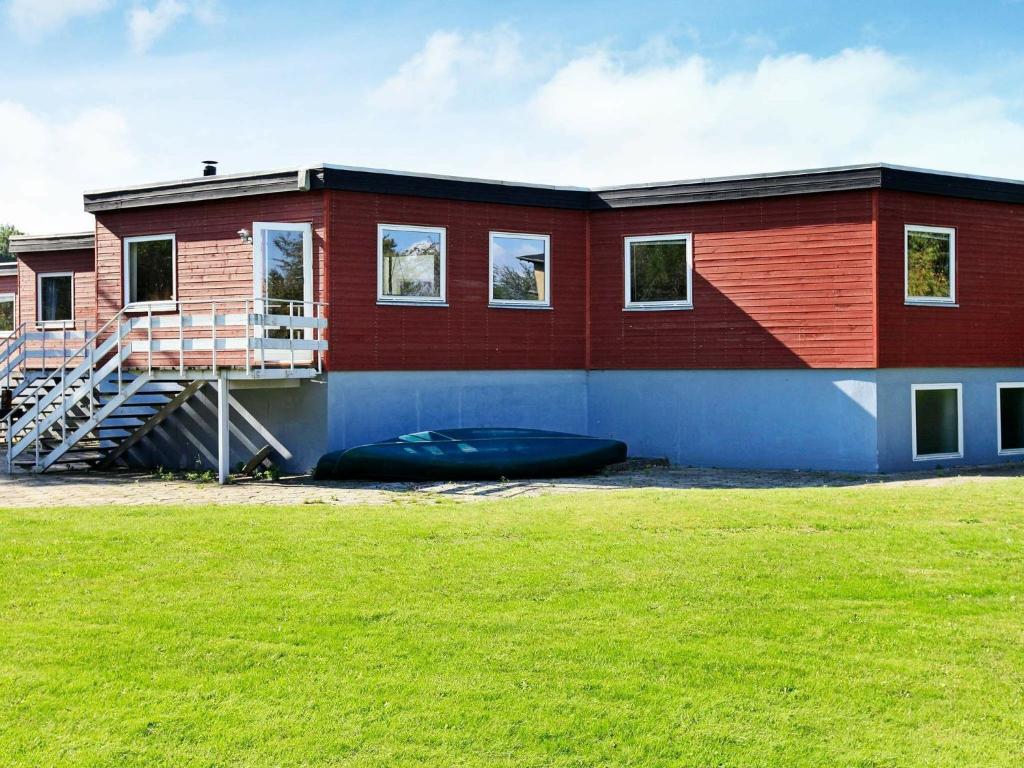 a red building with a ramp and a grass field at 30 person holiday home in Nordborg in Nordborg