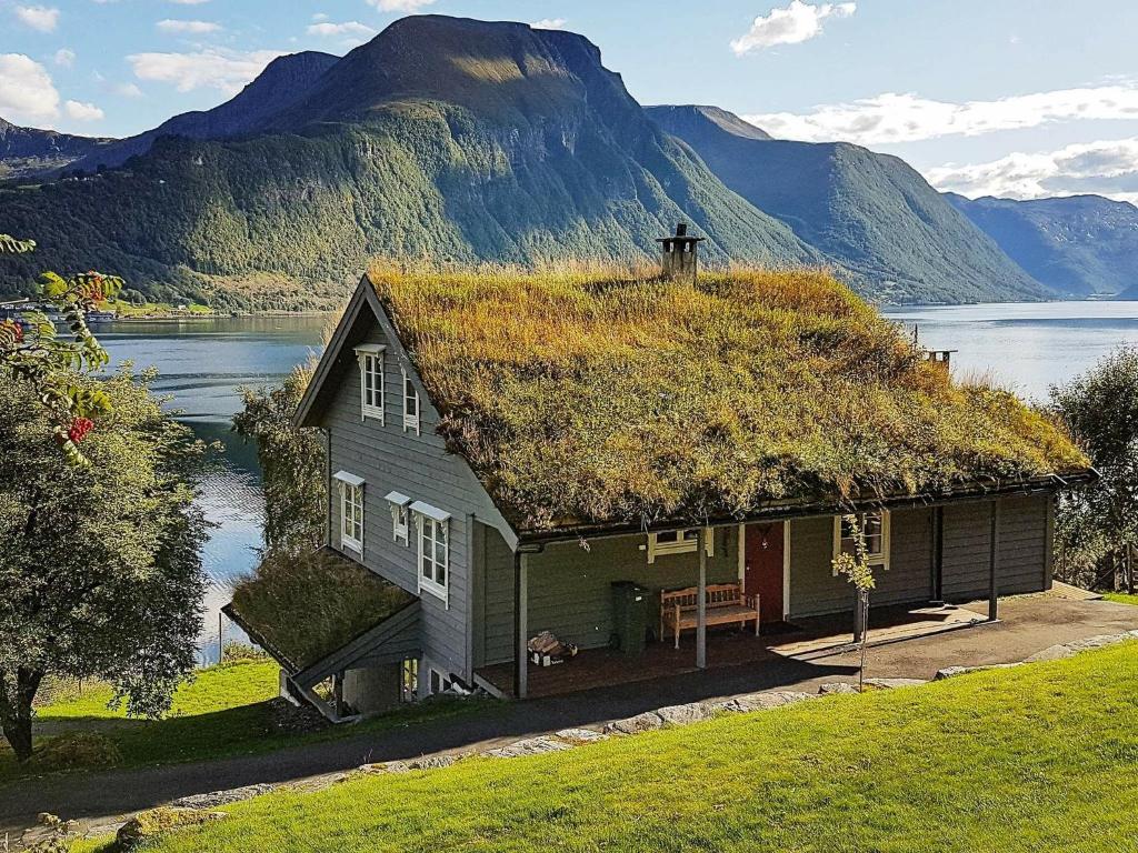 a house with a grass roof with a mountain in the background at 11 person holiday home in Lauvstad in Åmelfot