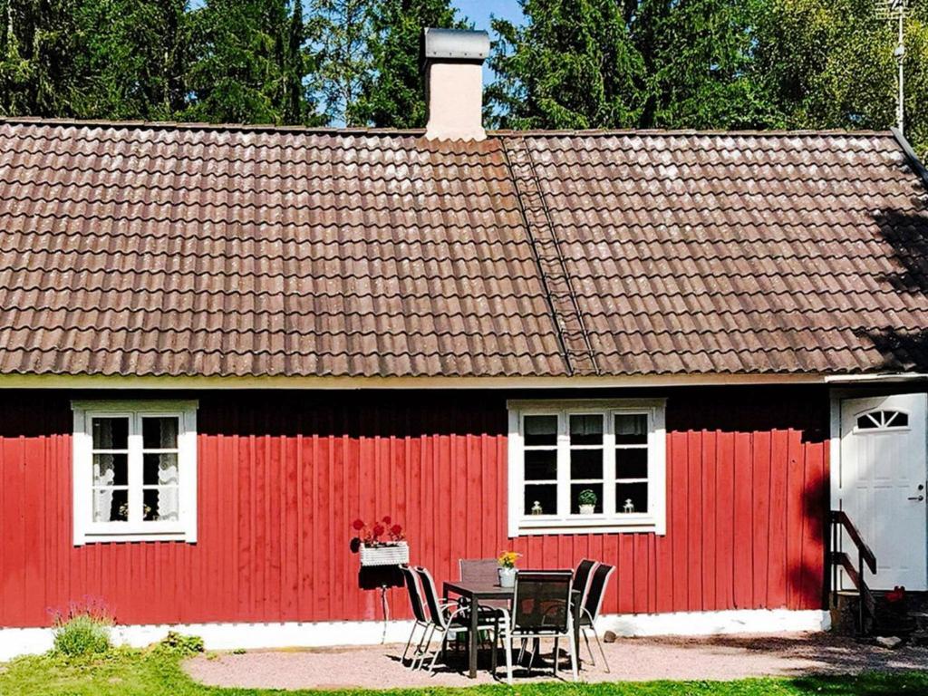 a red building with a table and chairs in front of it at 6 person holiday home in Vittsj in Ubbalt