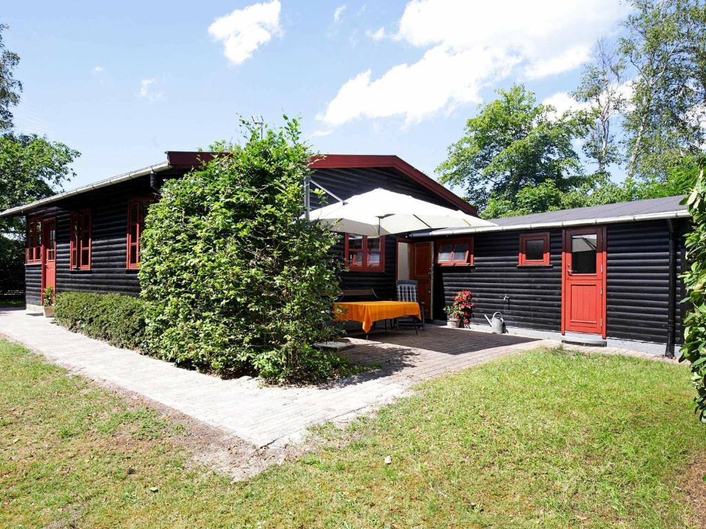 a house with a red door and a yard at 6 person holiday home in Gilleleje in Gilleleje