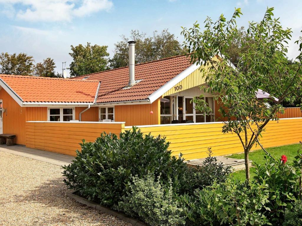a house with a yellow fence in front of it at 6 person holiday home in Hemmet in Hemmet