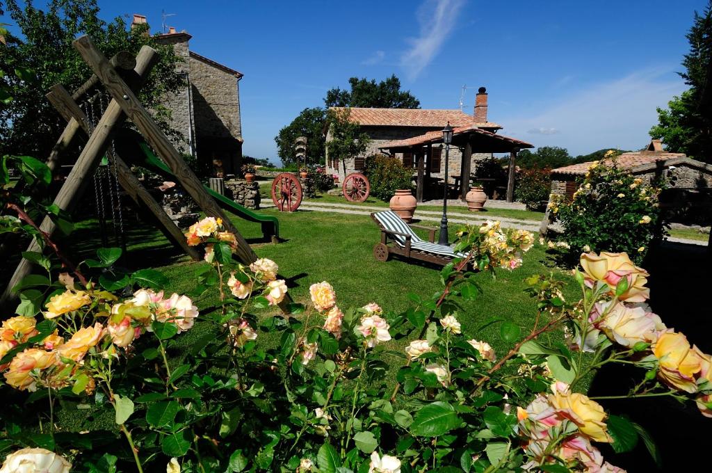 un jardín con un banco y flores frente a una casa en Agriturismo I Monti, en Semproniano