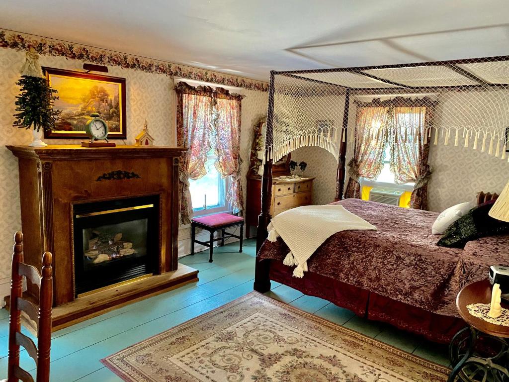 1 dormitorio con 1 cama y chimenea en The Bella Ella Bed and Breakfast, en Canandaigua